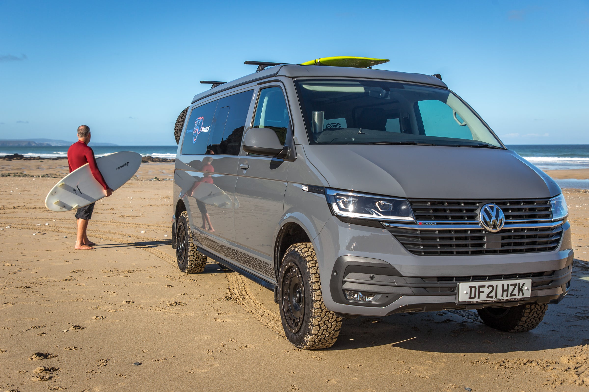 Man with surf board and Ecowagon's demo transporter van